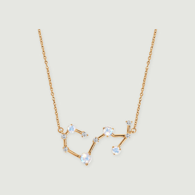 A yellow gold necklace displays an angular constellation with four pale round stones and smaller clear stones.