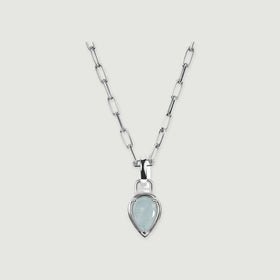 A pale blue pear-shaped aquamarine pendant hangs from a silver-colored elongated link chain on a light gray surface.