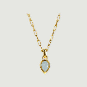 A yellow gold-colored link necklace with a pale blue pear-shaped pendant is centered on a light gray background.