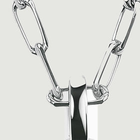 Interlocking silver-colored elongated links meet a broad polished bail against a light gray background.