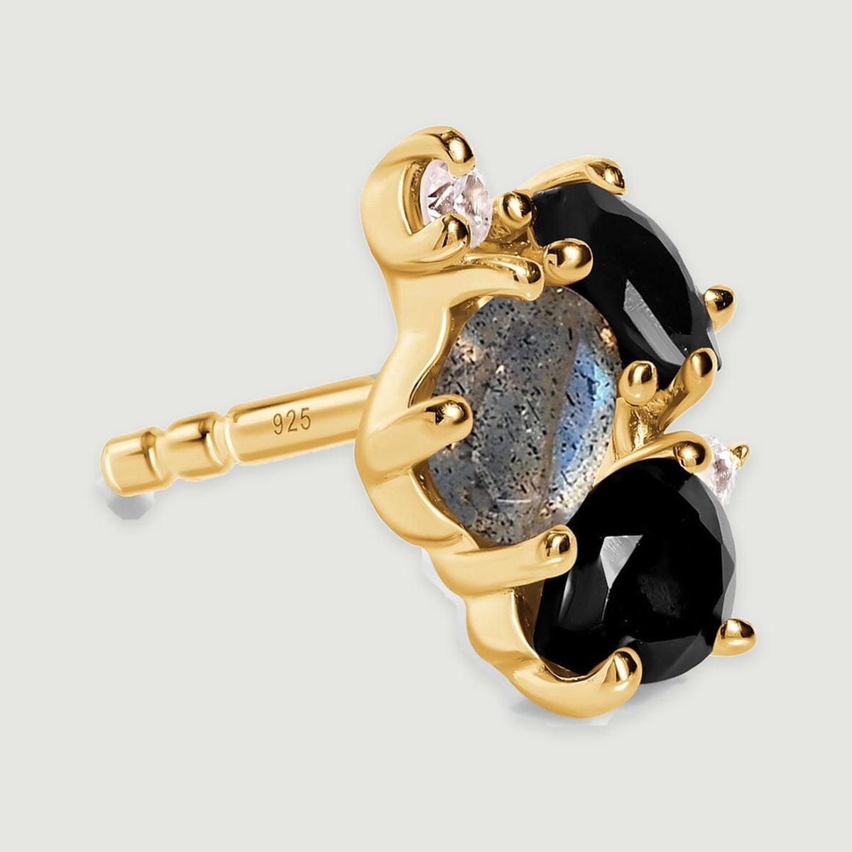 The angled side of a yellow gold vermeil stud earring shows the post, curved settings and raised gemstone cluster.