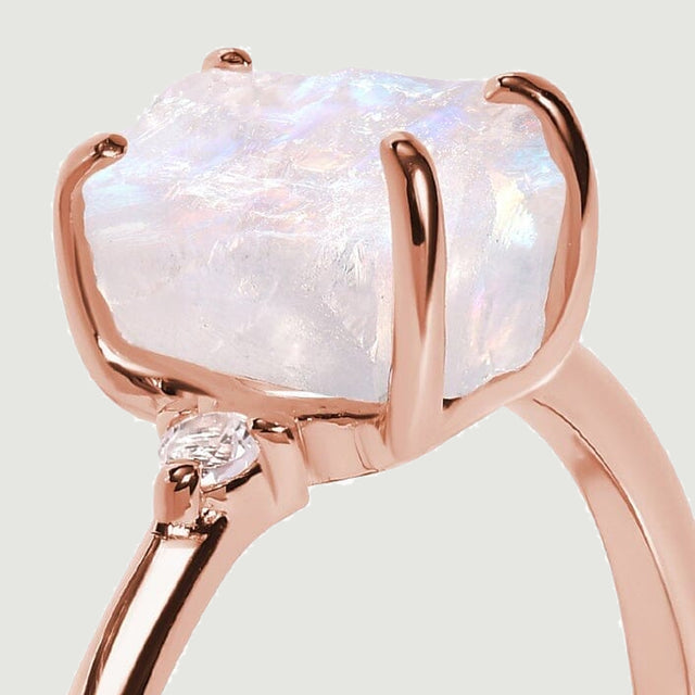 Rose gold claws wrap around the textured moonstone, with one round diamond visible at the shoulder.