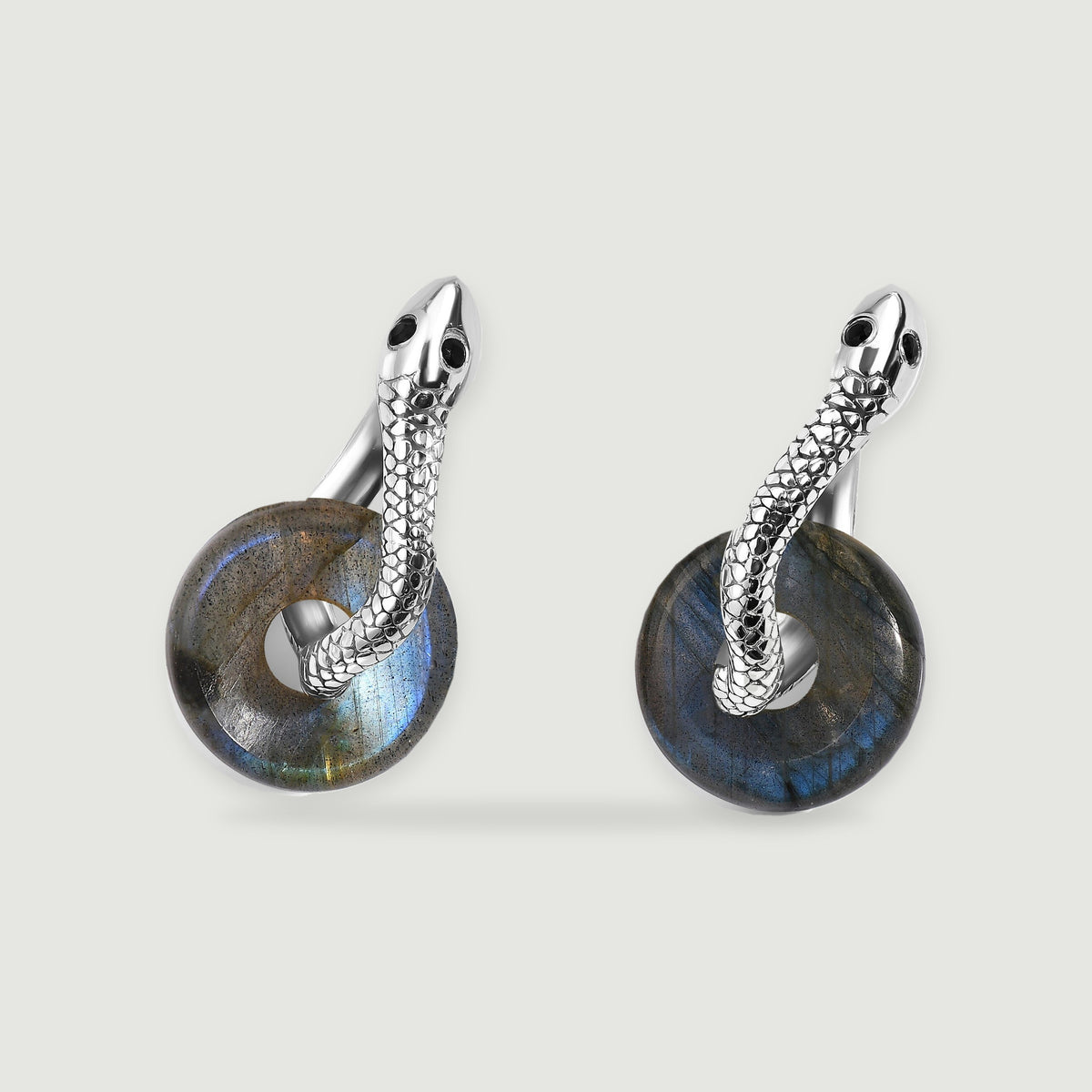 Two rhodium-tone earrings show polished circular labradorite drops beneath textured hoops.