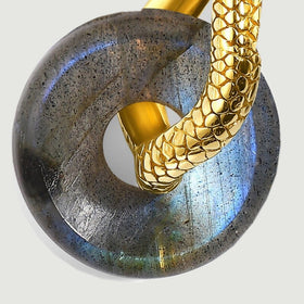 Blue and green reflections cross the rounded labradorite beneath a textured gold-tone hoop.