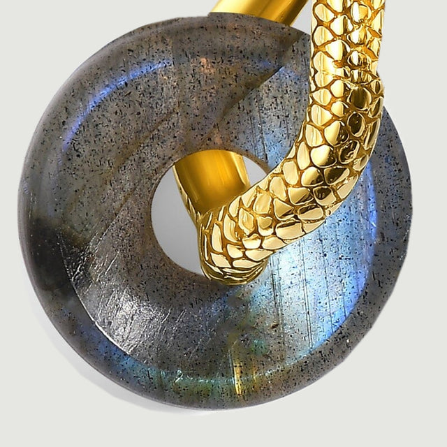 Blue and green reflections cross the rounded labradorite beneath a textured gold-tone hoop.