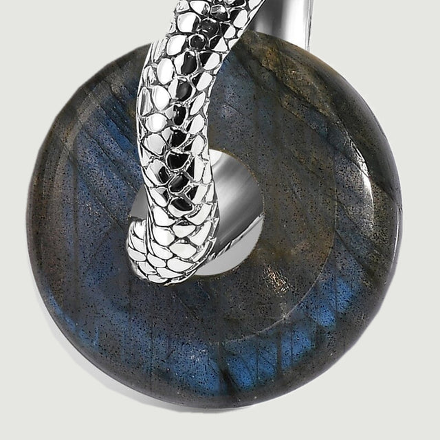 A close view shows dark mineral flecks and blue reflections around the rhodium-tone curve.