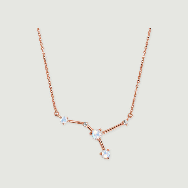 A rose gold vermeil chain leads to a branching arrangement of three pale stones and two smaller clear stones.