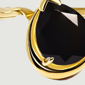 The curved left shoulder meets the raised gold rim beside the black stone.
