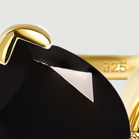 The pointed black stone sits beneath a gold tip claw with a 925 mark on the inner band.
