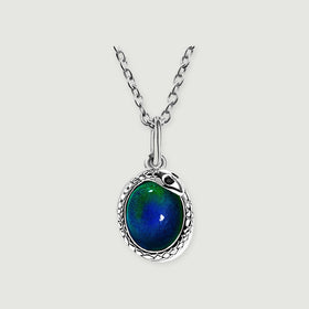 A silver-toned necklace with an oval blue-green pendant rests centrally on a light gray background.