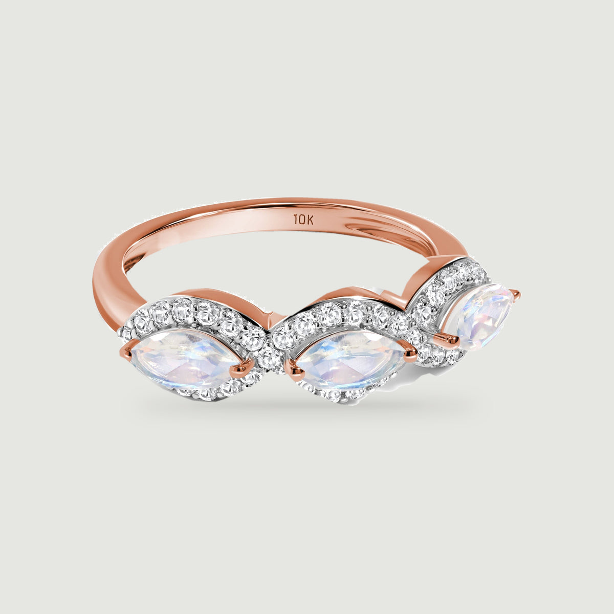 A rose gold band curves behind three pale marquise moonstones framed by small round diamonds.