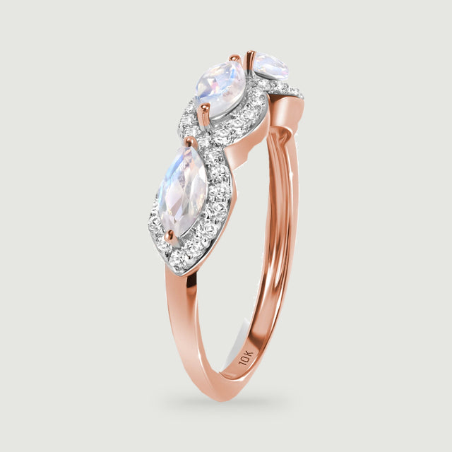 A rose gold ring stands on its edge with pale faceted stones above the curved band.