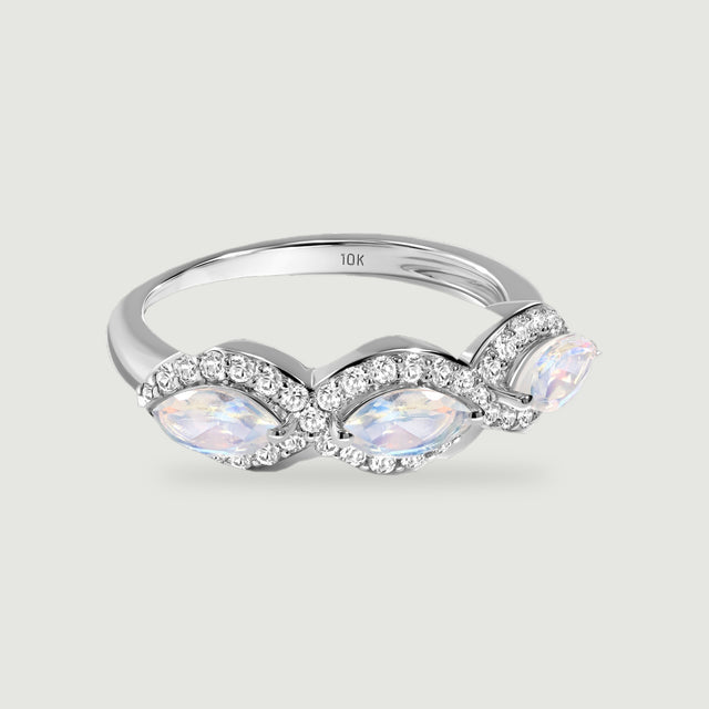 A white gold ring displays three iridescent marquise moonstones with curved diamond borders on a light gray surface.