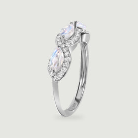 An upright white gold ring reveals the side of its moonstone settings and a slim polished band.