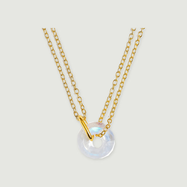 A yellow gold vermeil necklace with an open-centre moonstone pendant is shown against light grey.