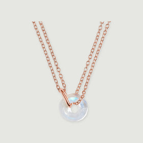 A rose gold vermeil double chain passes through a polished connector beside a round moonstone pendant.
