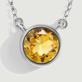A close view shows the faceted yellow citrine, polished circular bezel, and the chain attachments on both sides.
