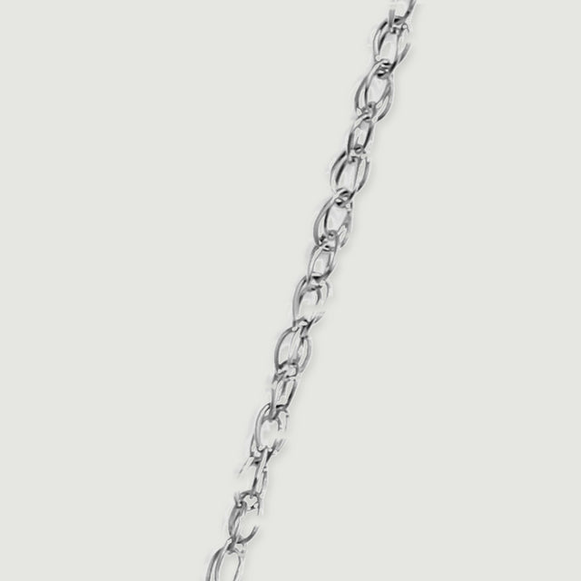 Interlocking white gold oval chain links run diagonally across a pale grey surface.