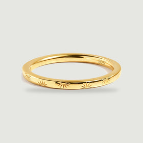 A yellow gold band displays alternating engraved rays and a smooth reflective interior.