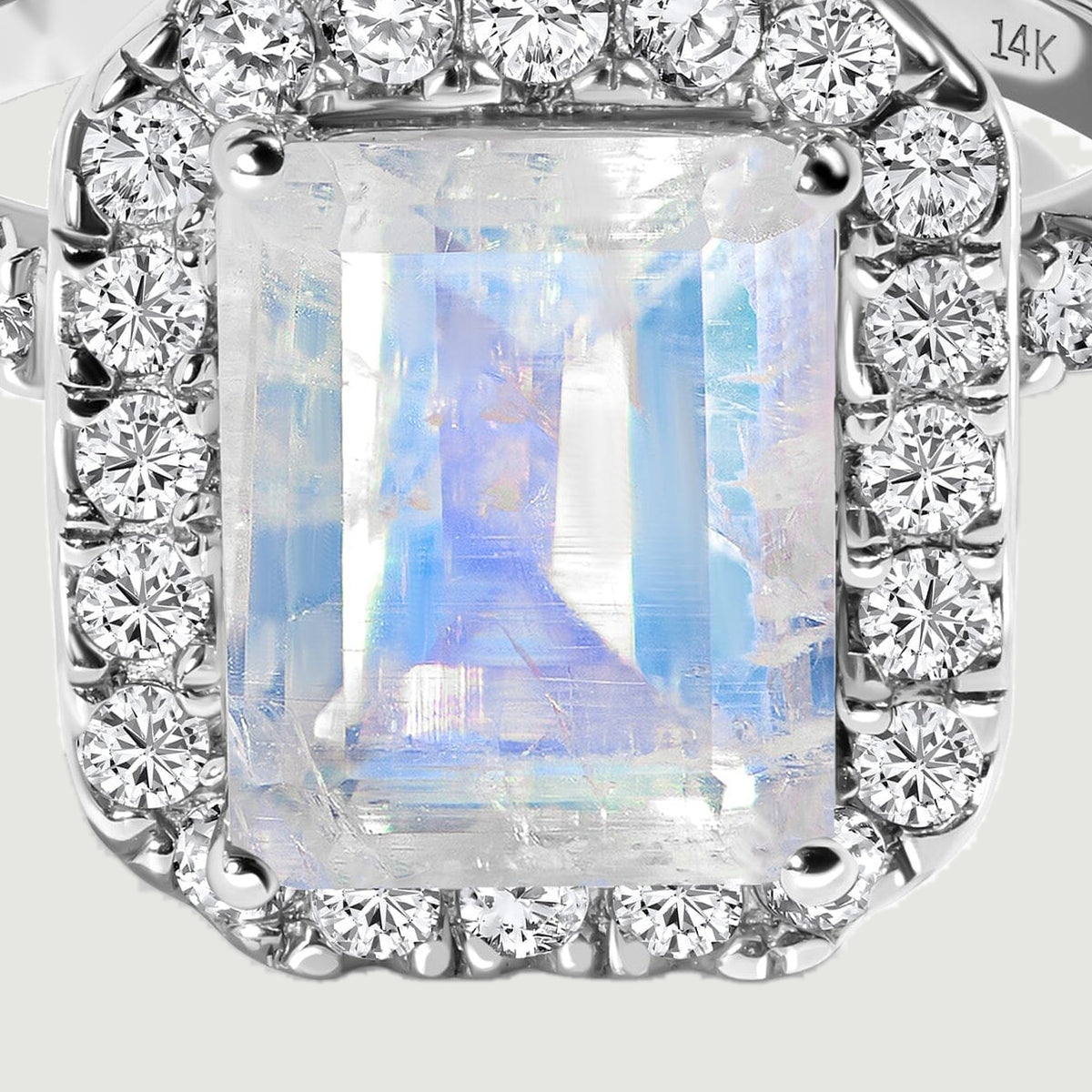 Blue and pale violet reflections appear across the moonstone beside bright diamonds in white gold.
