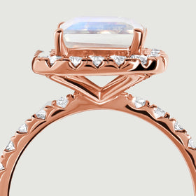 Rose gold supports form an open triangular gallery beneath the moonstone and its diamond border.