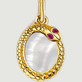 A close view shows the yellow gold plated rim around the oval mother of pearl and its two red details.