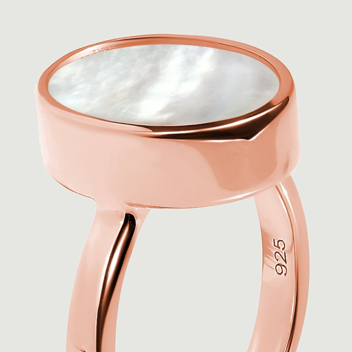 The smooth rose gold setting surrounds the flat oval mother-of-pearl insert.