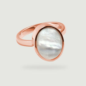 The rose gold ring lies at a diagonal on a clean light gray surface with a soft shadow.