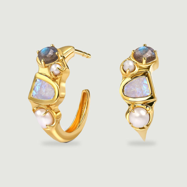 Yellow-gold-tone hoop earrings stand side by side, showing pale central stones, smaller round stones and white pearls.