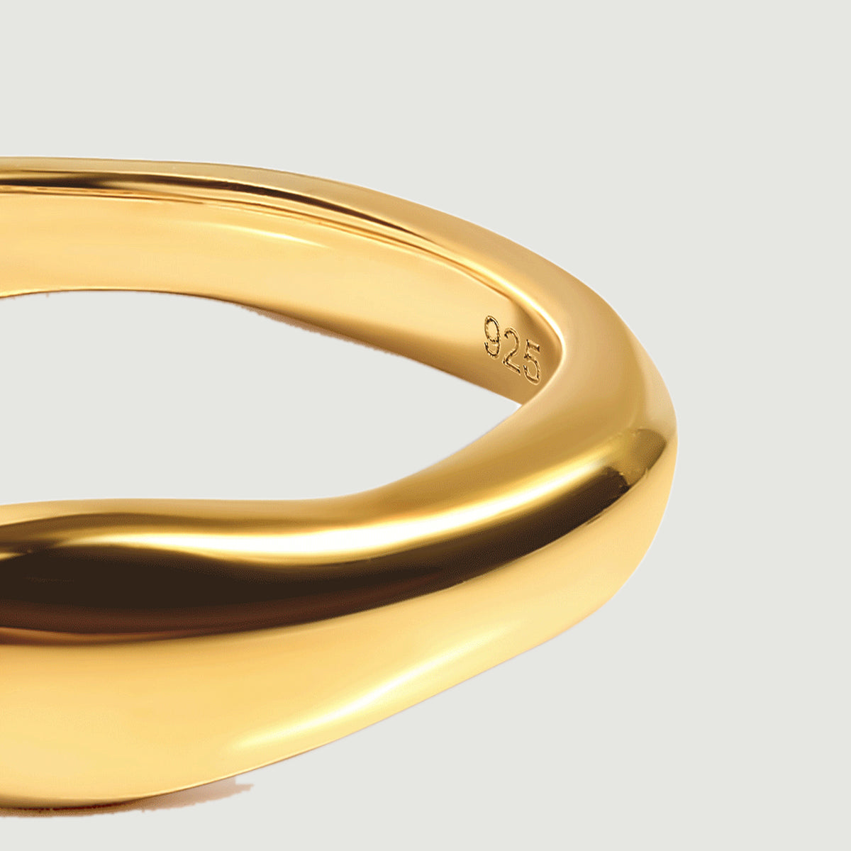 A close view of the yellow gold vermeil ring shows its rounded side and the 925 stamp inside the band.