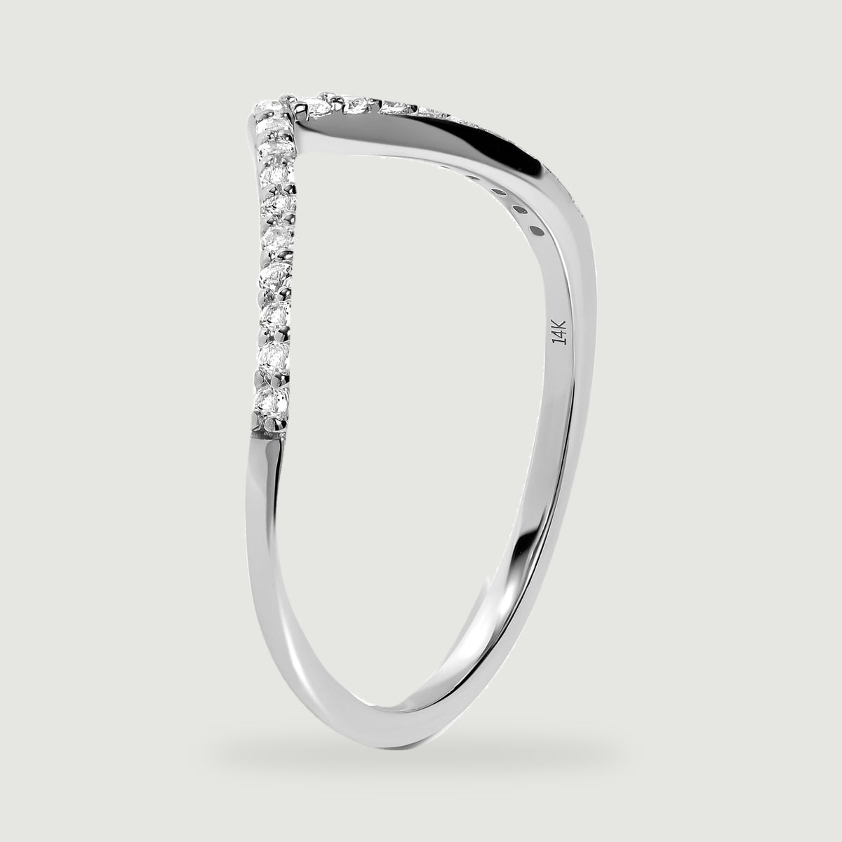 An upright white gold ring reveals its polished side, small stone settings, and inner 14K stamp.