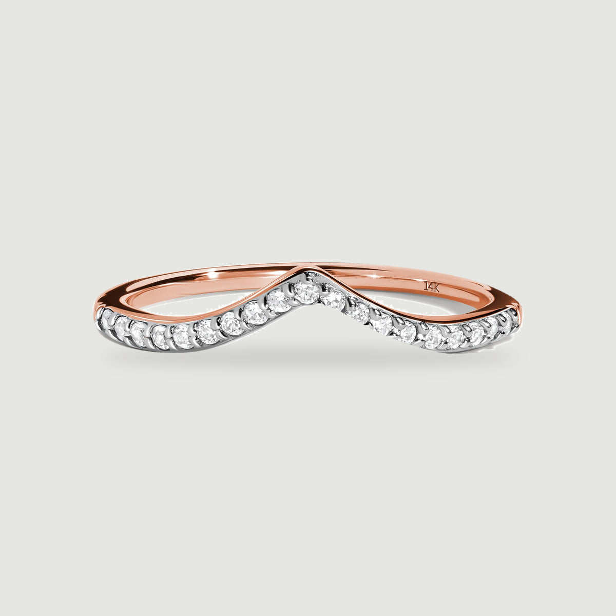 A rose gold ring displays round diamonds along its curved pointed front.
