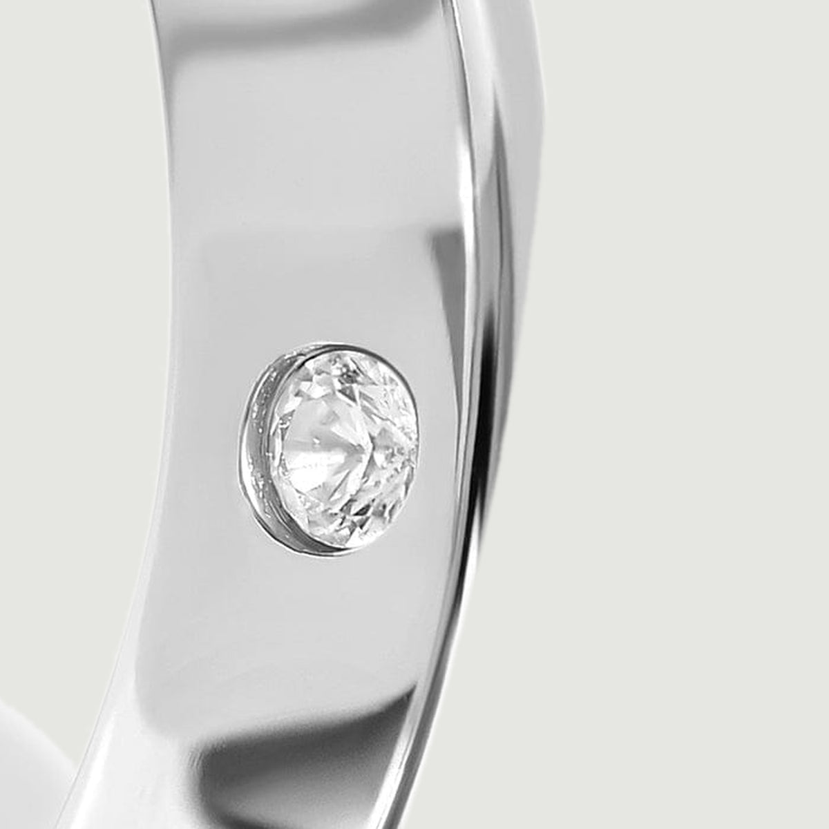 A close view reveals the clear inner stone beside the curved polished edge of the silver ring.