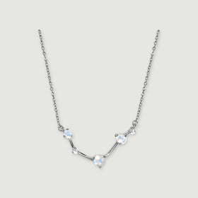 A silver necklace shows blue flashes in three faceted moonstones with small clear accents between them.