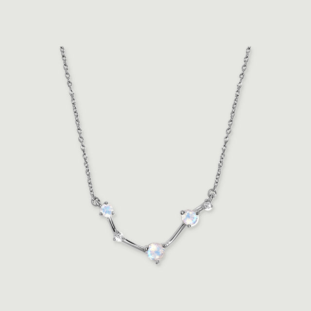 A silver necklace shows blue flashes in three faceted moonstones with small clear accents between them.