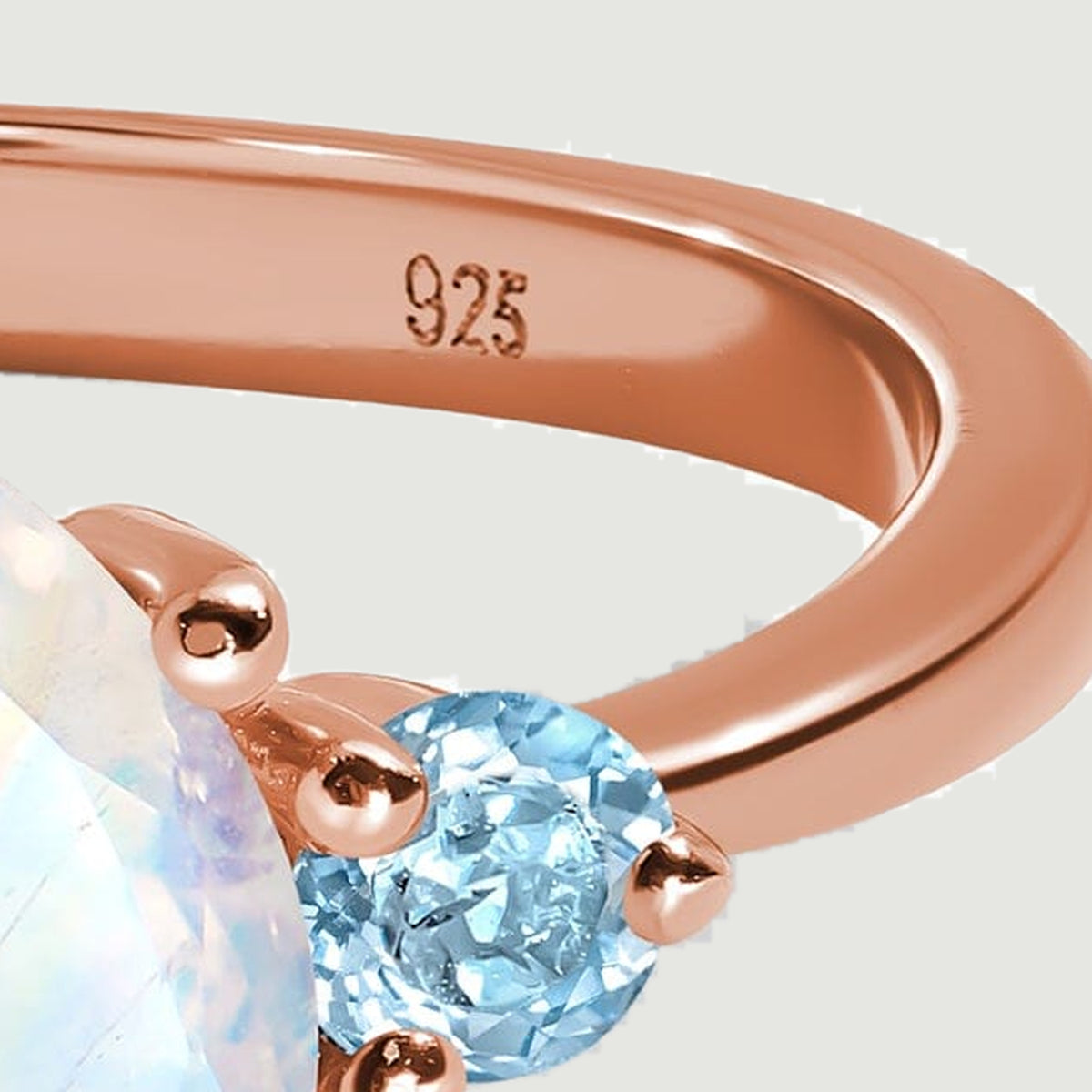 A close view of the inner rose gold band shows a 925 stamp above a light blue side stone.