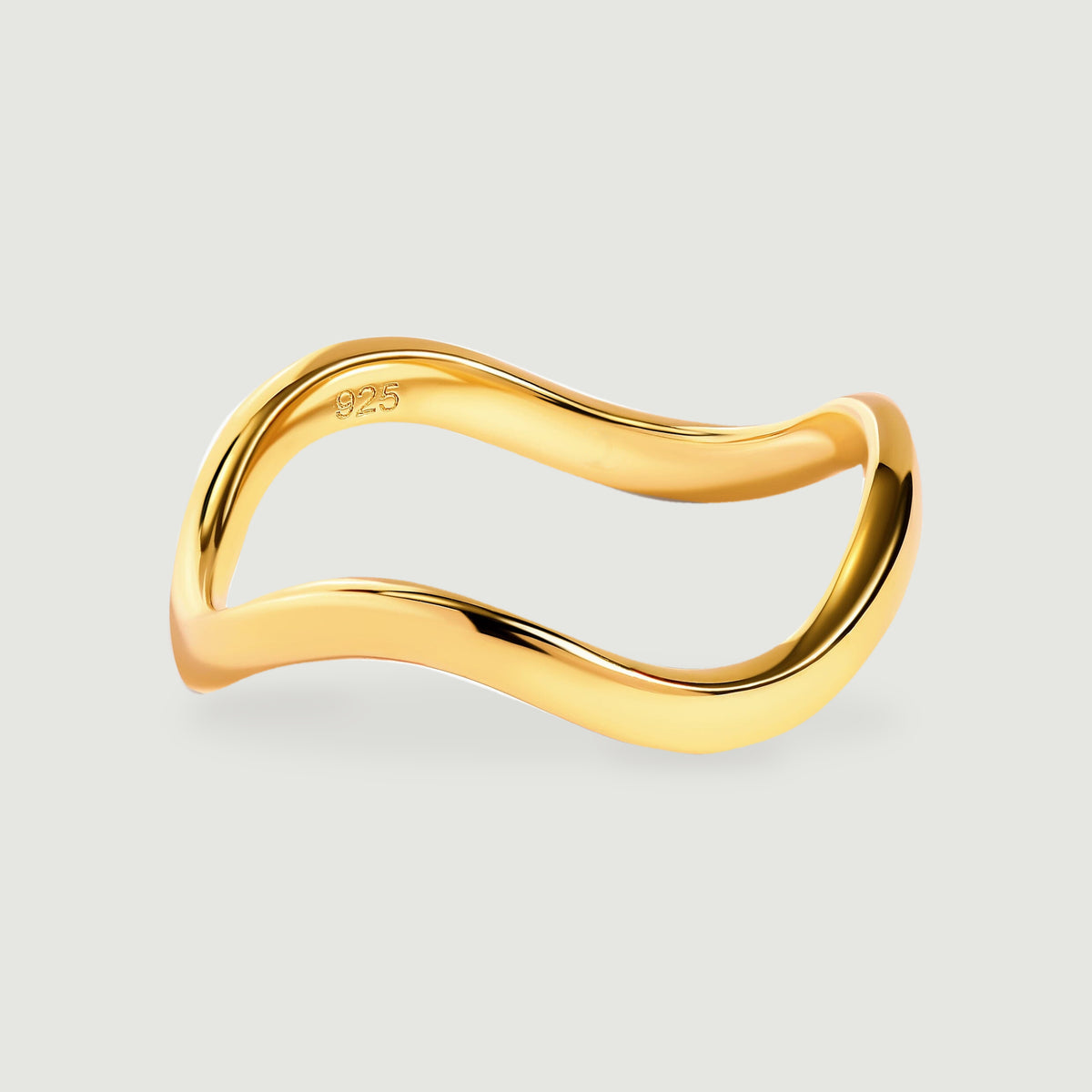 A yellow gold ring with a smooth contoured band is centered above a soft shadow.