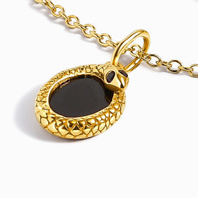 An angled yellow gold pendant reveals its raised textured edge and adjoining chain links.