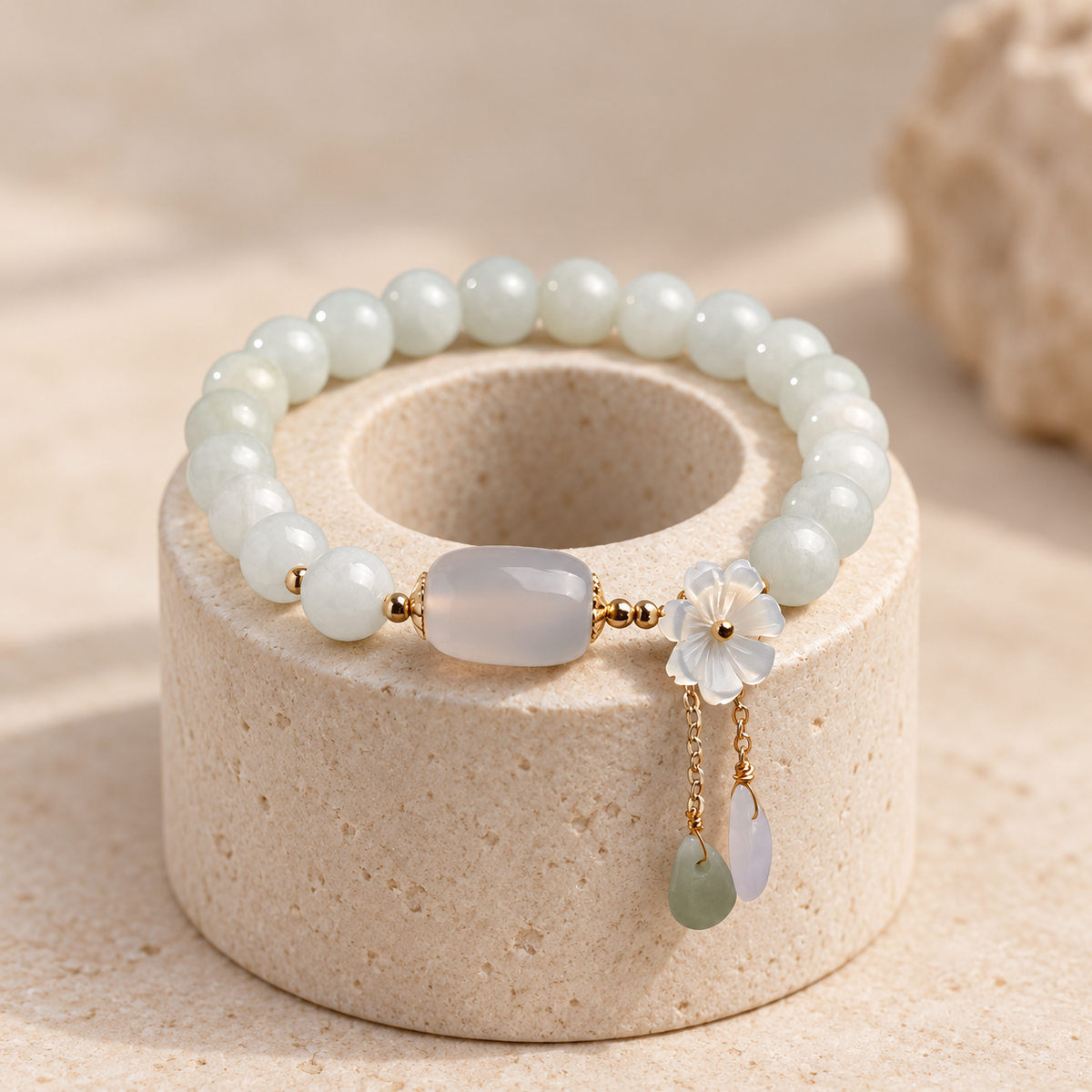 White bead bracelet with a barrel centerpiece, flower charm and hanging accents; AI-edited draft reference.
