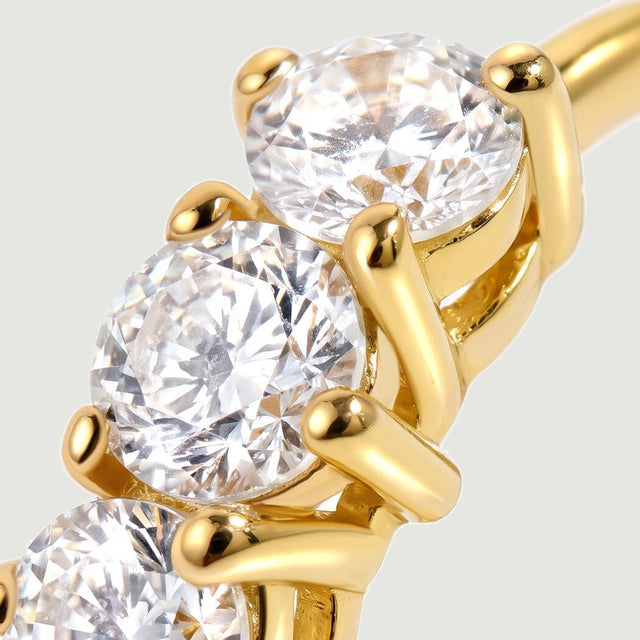 Clear brilliant-cut stones sit in bright yellow gold-tone claw settings.