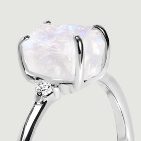 The side of the silver setting shows the rough stone edge, curved prongs and a small round shoulder stone.