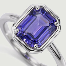 A close angled view reveals a violet rectangular gemstone and its polished silver setting.