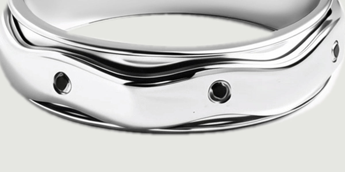 The turned outer band displays black stones beneath an undulating polished silver edge.