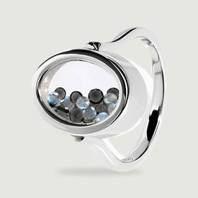 An angled sterling silver ring reveals its oval chamber, reflective band, and small round black and blue gray gems.