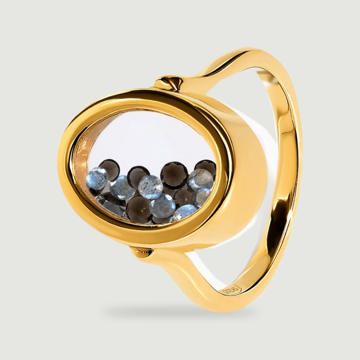 The yellow gold vermeil ring is tilted to show the depth of its clear oval chamber and the curved band behind it.