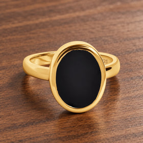 Stillpoint black onyx oval ring in yellow gold vermeil, complete front view on walnut.