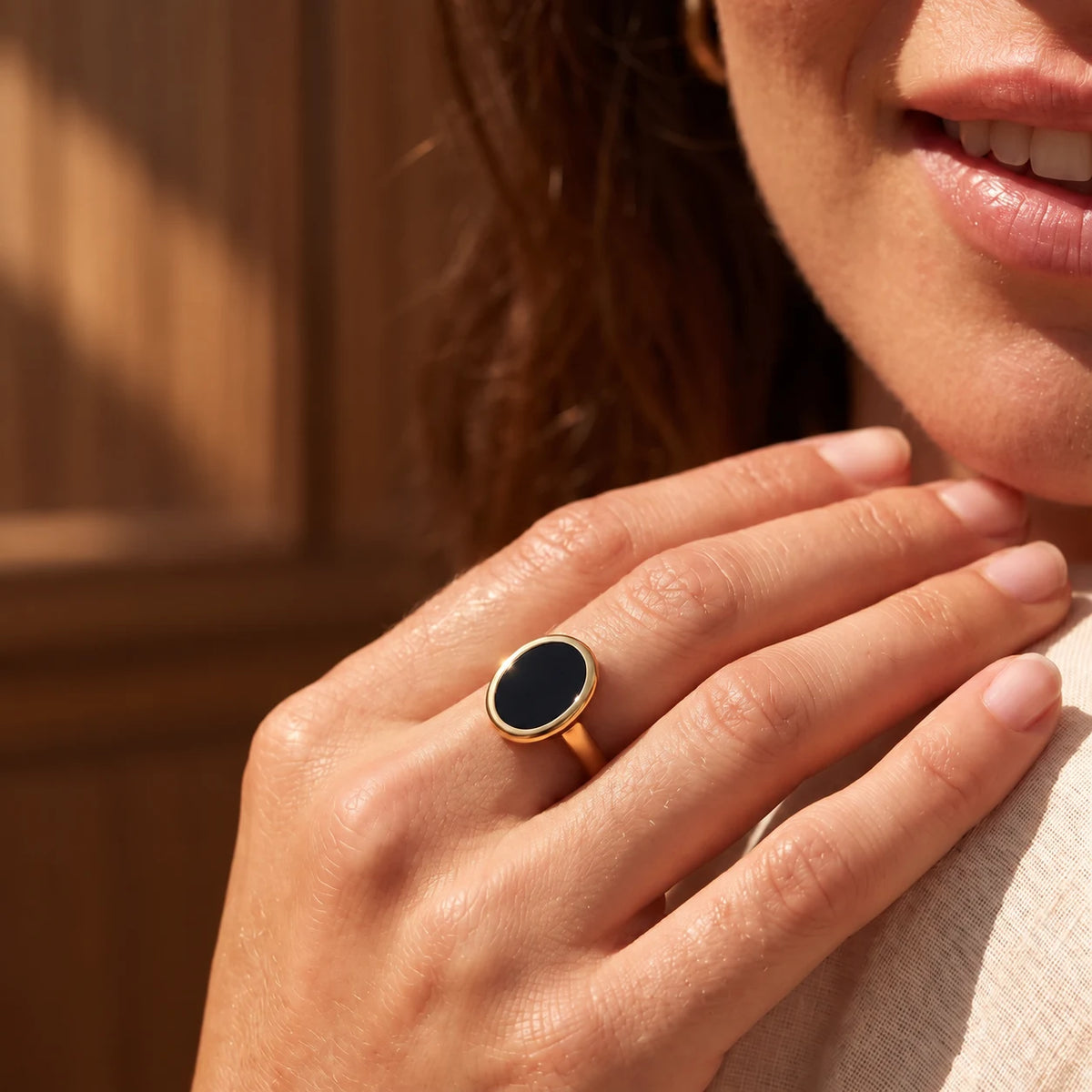 Stillpoint black onyx oval ring in yellow gold vermeil, shown on hand for scale.