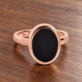 Stillpoint black onyx oval ring in rose gold vermeil, complete front view on walnut.
