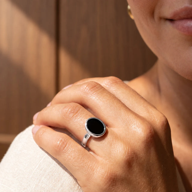 Stillpoint black onyx oval ring in sterling silver, shown on hand for scale.