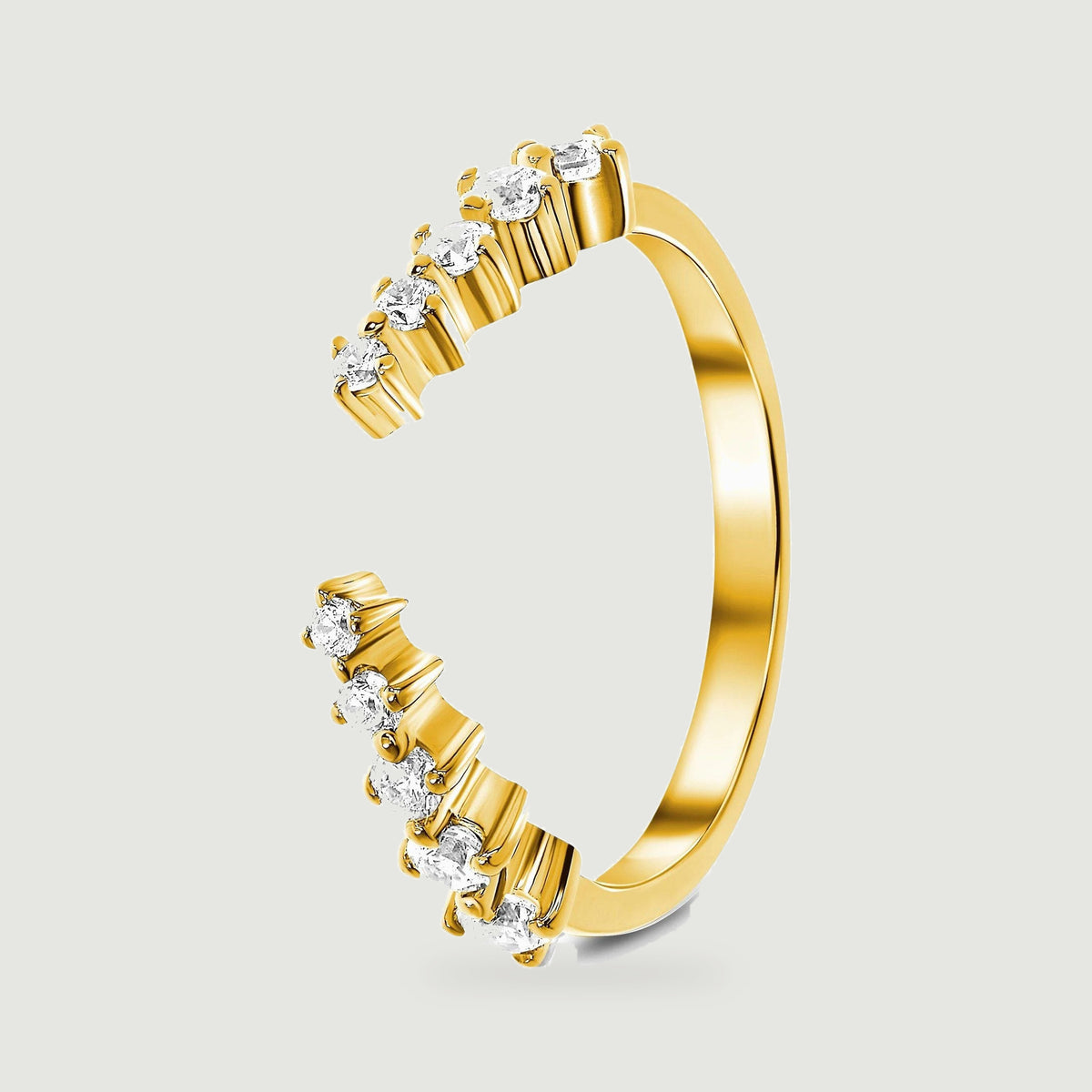 A yellow gold vermeil ring is shown from the side with polished prongs holding round clear stones.